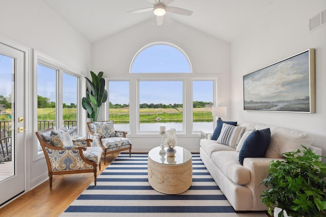 sunroom / solarium with a water view, vaulted ceiling, and ceiling fan