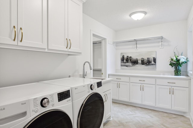 laundry area featuring cabinets, sink, washing machine and dryer, a textured ceiling, and light parquet flooring