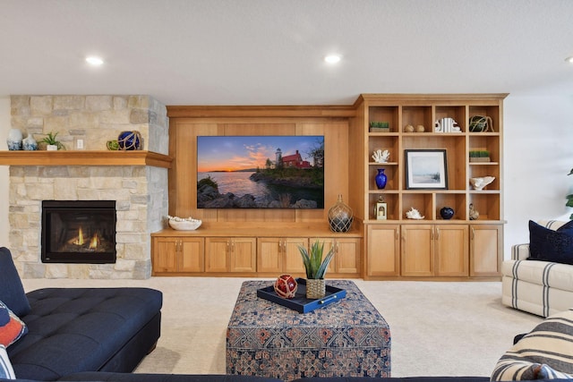 carpeted living room with a stone fireplace