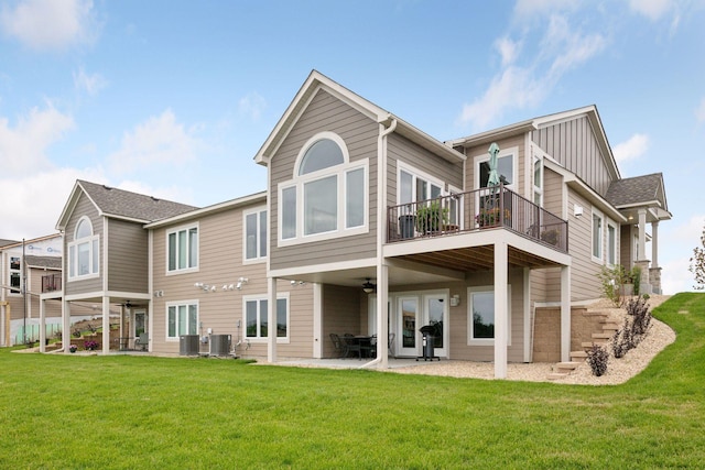 rear view of house with central AC, a patio area, and a yard