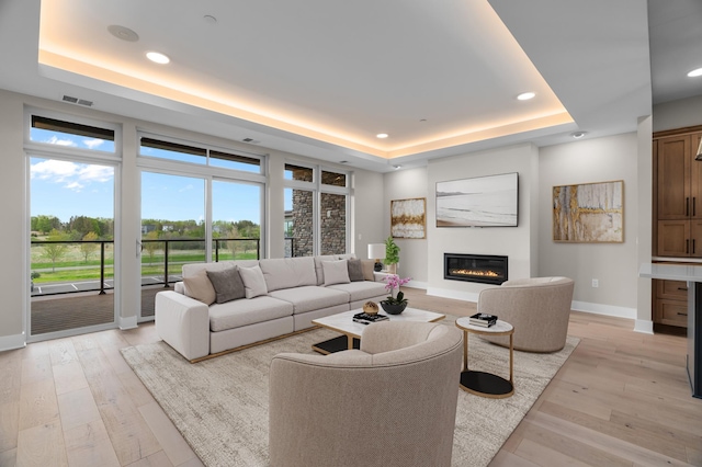 1 Hill Farm Rd Unit 205, North Oaks, MN 55127 - living room with a raised ceiling, baseboards, a glass covered fireplace, light wood finished floors, and recessed lighting