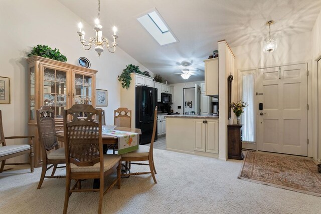 carpeted dining room featuring ceiling fan with notable chandelier and vaulted ceiling