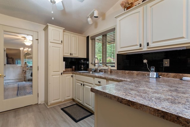 kitchen featuring ceiling fan, sink, a textured ceiling, light hardwood / wood-style floors, and decorative backsplash