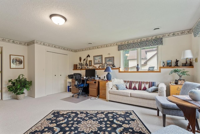 carpeted office space with a textured ceiling