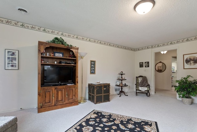 living room featuring light colored carpet and a textured ceiling