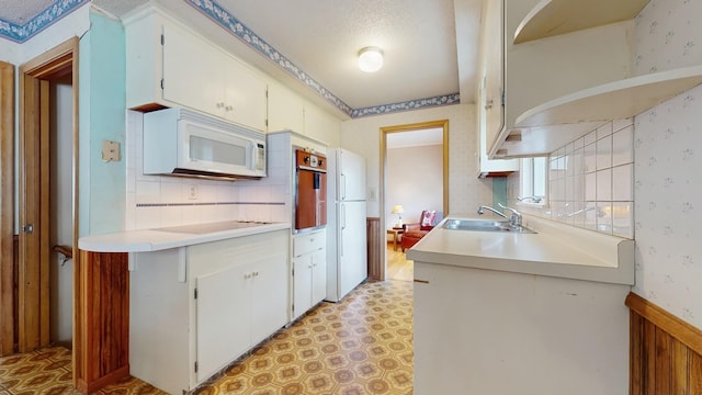 4200 Overlook Dr, Bloomington, MN 55437 - kitchen with white appliances, light flooring, wallpapered walls, light countertops, and white cabinets