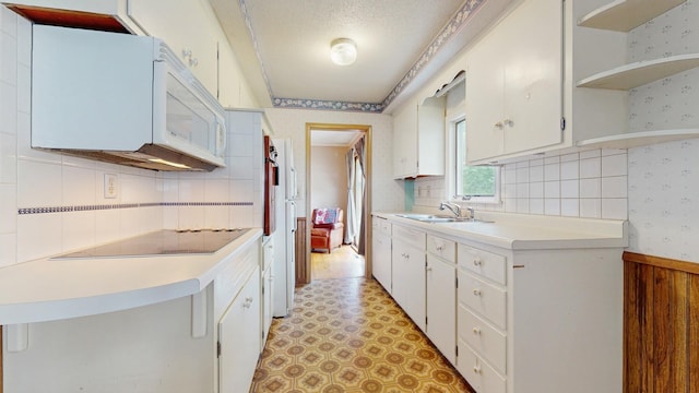 4200 Overlook Dr, Bloomington, MN 55437 - kitchen featuring wallpapered walls, black electric cooktop, open shelves, light countertops, and white cabinetry