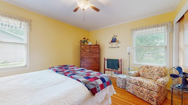 4200 Overlook Dr, Bloomington, MN 55437 - bedroom featuring wood finished floors, multiple windows, ornamental molding, a ceiling fan, and a closet