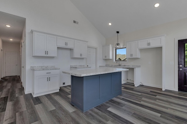 kitchen with white cabinets, pendant lighting, a kitchen island, dark hardwood / wood-style floors, and high vaulted ceiling