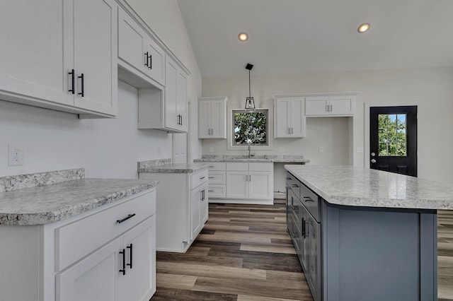 kitchen featuring decorative light fixtures, white cabinetry, dark hardwood / wood-style floors, a kitchen island, and lofted ceiling