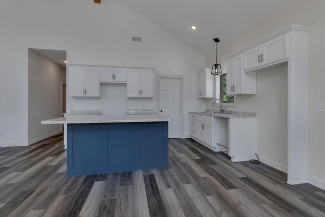 kitchen with decorative light fixtures, a kitchen island, high vaulted ceiling, white cabinetry, and dark hardwood / wood-style flooring