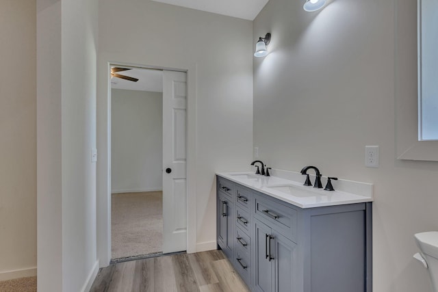 bathroom with dual vanity, ceiling fan, toilet, and hardwood / wood-style floors