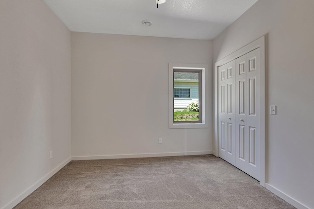 unfurnished bedroom with a closet and carpet flooring