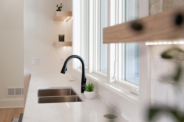 kitchen view of a sink, open shelves, and light countertops