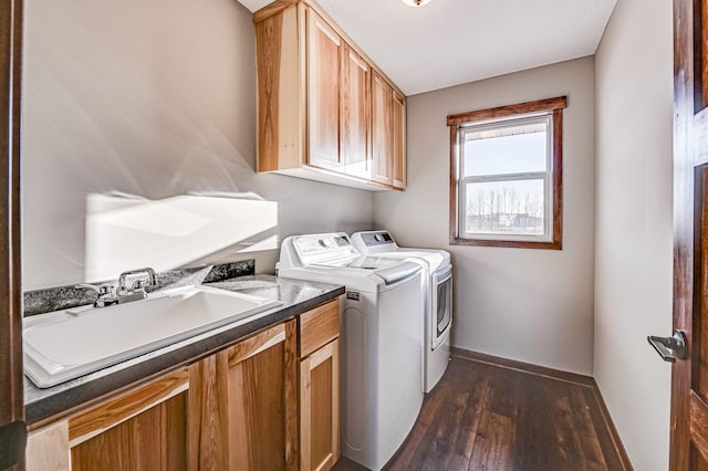 laundry room with cabinets, washer and dryer, sink, and dark hardwood / wood-style flooring