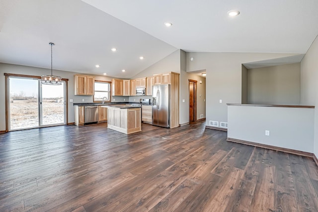 kitchen with dark wood-type flooring, a chandelier, a kitchen island, pendant lighting, and stainless steel appliances