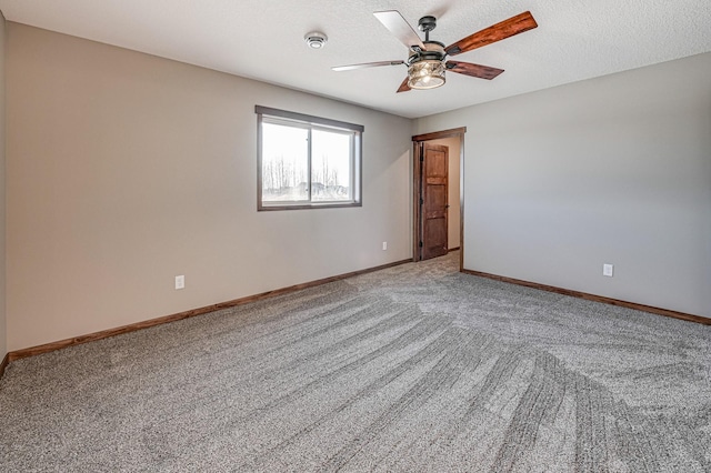 carpeted spare room with ceiling fan and a textured ceiling