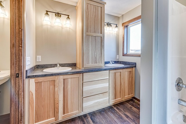 bathroom with vanity, hardwood / wood-style floors, and shower / washtub combination