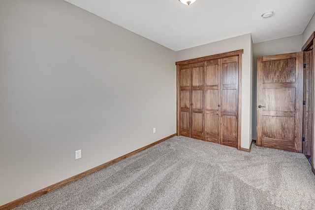 unfurnished bedroom featuring a closet and light carpet