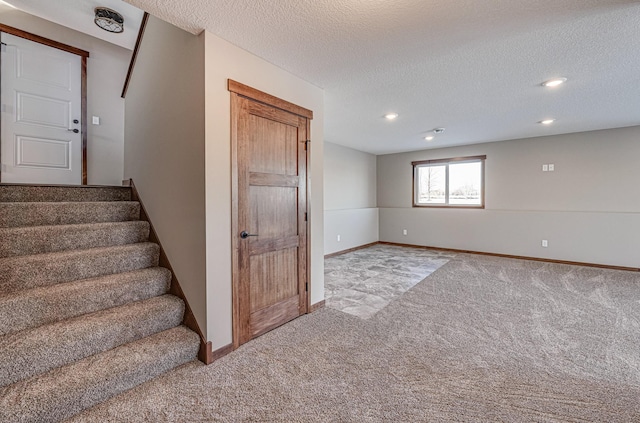 stairs with carpet floors and a textured ceiling