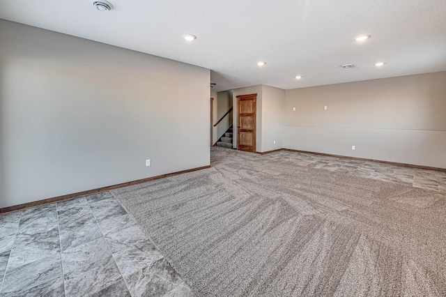 empty room with light colored carpet and a textured ceiling