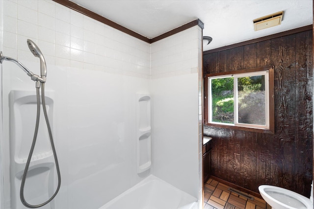 bathroom featuring wood walls, parquet flooring, and toilet