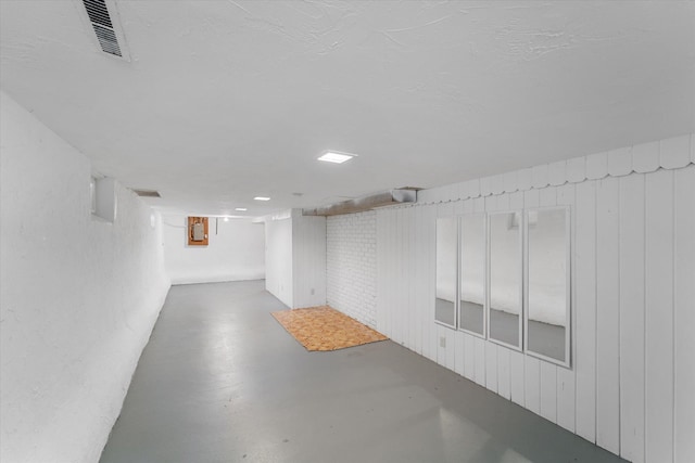 basement featuring wooden walls