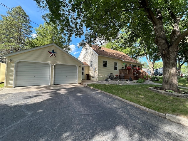 view of front facade featuring driveway, an outdoor structure, and a front yard