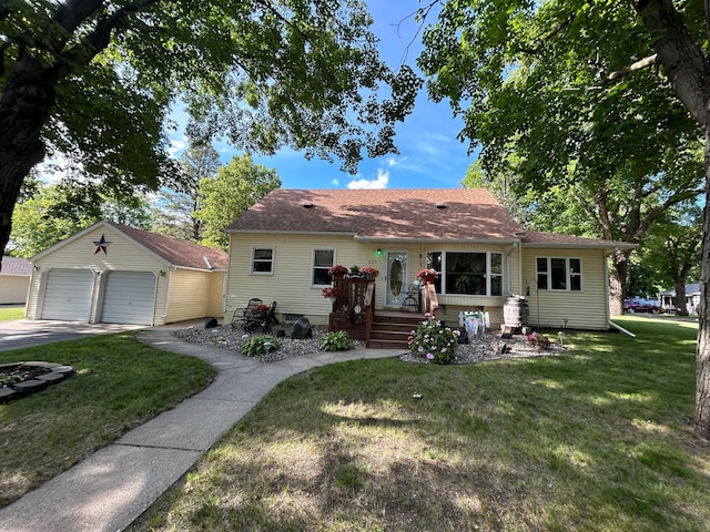 625 10th St, Montevideo, MN 56265 - view of front facade with a shingled roof, a front lawn, an outbuilding, and a detached garage