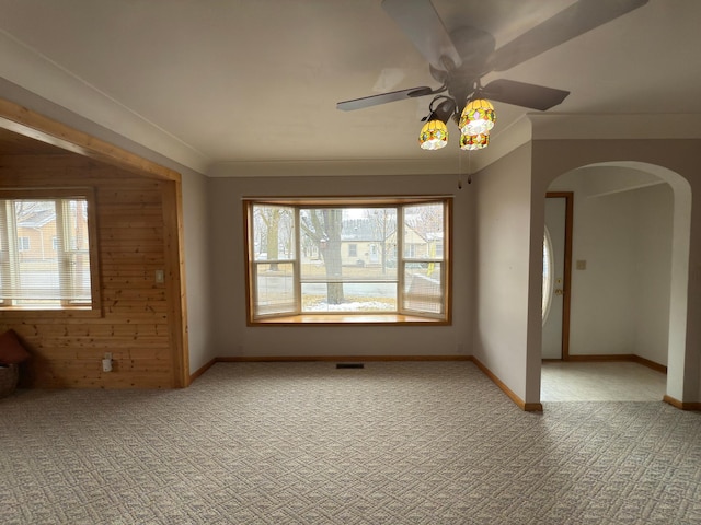 625 10th St, Montevideo, MN 56265 - spare room featuring arched walkways, baseboards, light colored carpet, and ceiling fan