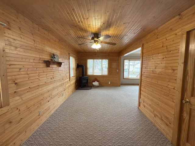 625 10th St, Montevideo, MN 56265 - interior space featuring wooden walls, carpet, a wood stove, and ceiling fan