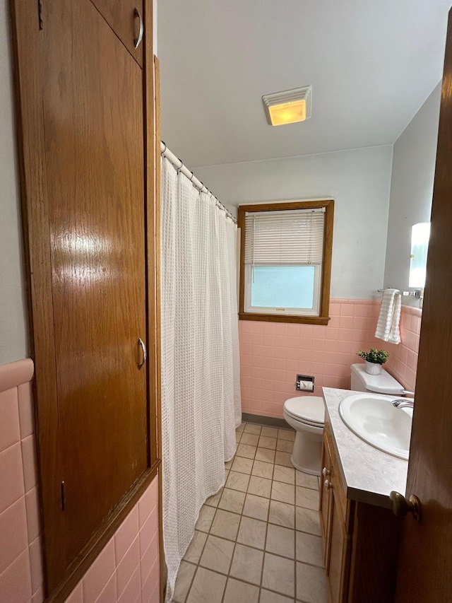 625 10th St, Montevideo, MN 56265 - bathroom with tile patterned floors, wainscoting, vanity, tile walls, and toilet