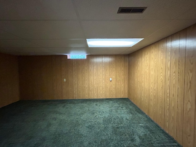 625 10th St, Montevideo, MN 56265 - below grade area with a paneled ceiling, wooden walls, visible vents, and carpet