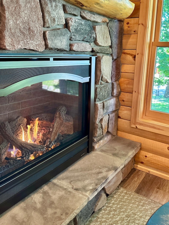 interior details with hardwood / wood-style floors and a stone fireplace