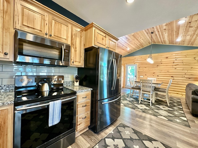 kitchen with light stone countertops, lofted ceiling, stainless steel appliances, and light hardwood / wood-style flooring