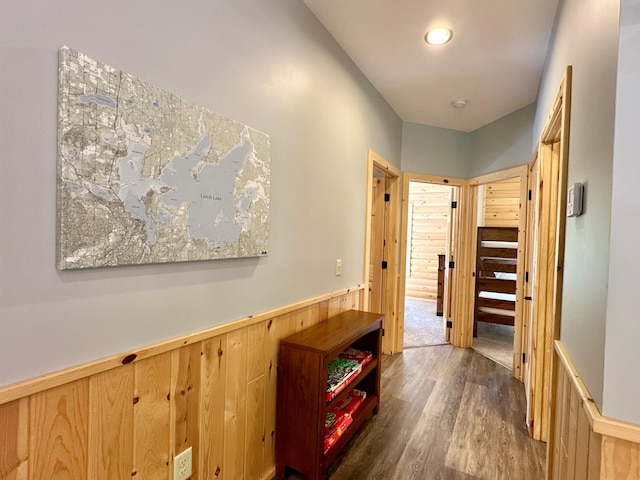 hall featuring wood walls and dark hardwood / wood-style flooring