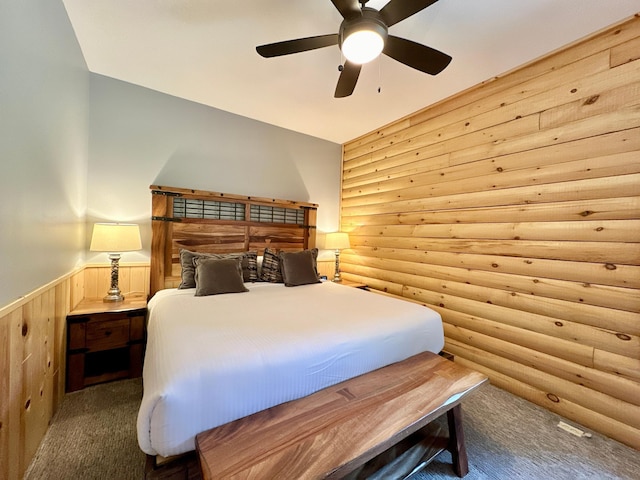 carpeted bedroom featuring ceiling fan and log walls