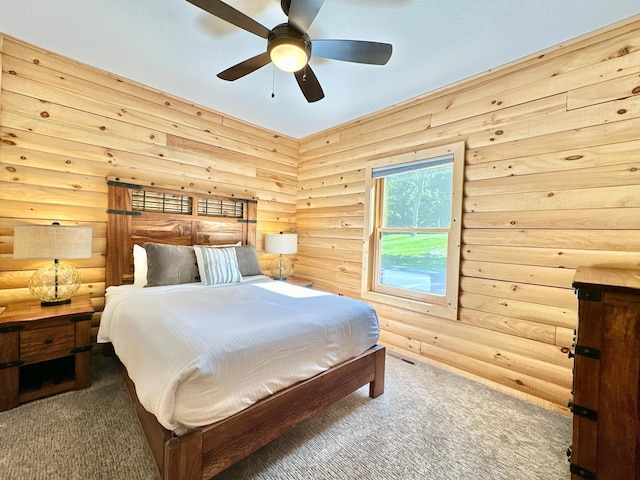 carpeted bedroom with ceiling fan and log walls