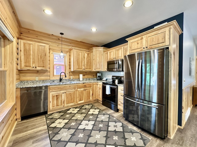 kitchen featuring light stone countertops, wood walls, and appliances with stainless steel finishes