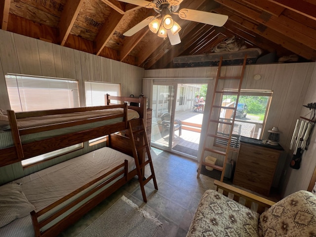 tiled bedroom with wood walls, lofted ceiling with beams, access to exterior, and ceiling fan