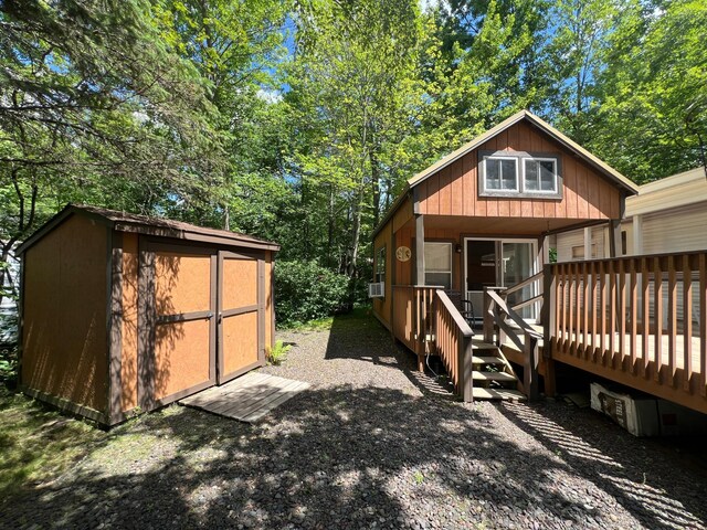 view of property exterior with a storage unit and a wooden deck