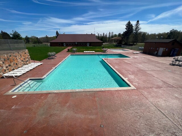 view of swimming pool with a patio and a yard