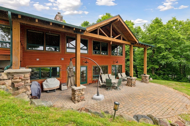 back of house with a patio and a fire pit