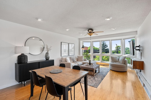 living room with recessed lighting, a ceiling fan, a textured ceiling, light wood-type flooring, and baseboards