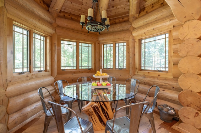 dining room featuring beamed ceiling, light wood-type flooring, a notable chandelier, and rustic walls