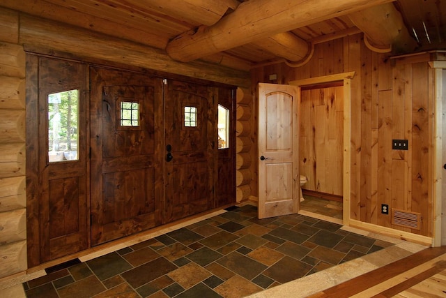 entrance foyer with wooden walls, wooden ceiling, and beam ceiling