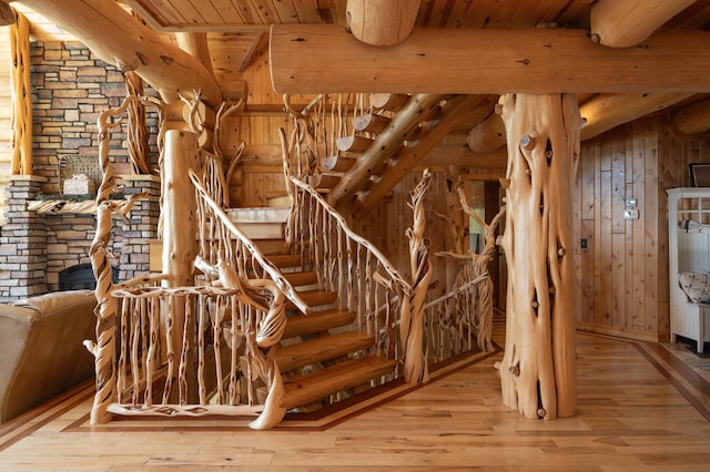 stairway featuring hardwood / wood-style flooring, beam ceiling, and wood ceiling