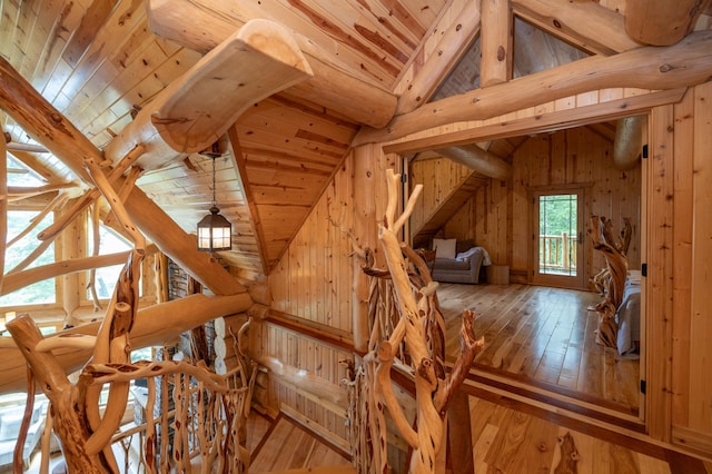 interior space with light wood-type flooring, wood walls, lofted ceiling with beams, and wood ceiling