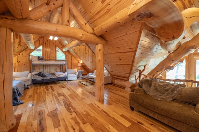 interior space with wood walls, light hardwood / wood-style floors, wooden ceiling, and vaulted ceiling with beams