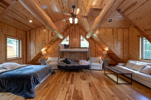 bedroom with light wood-type flooring, vaulted ceiling with beams, wooden ceiling, and multiple windows